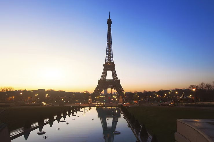 The Eiffel Tower at dusk with a view of Paris in the background